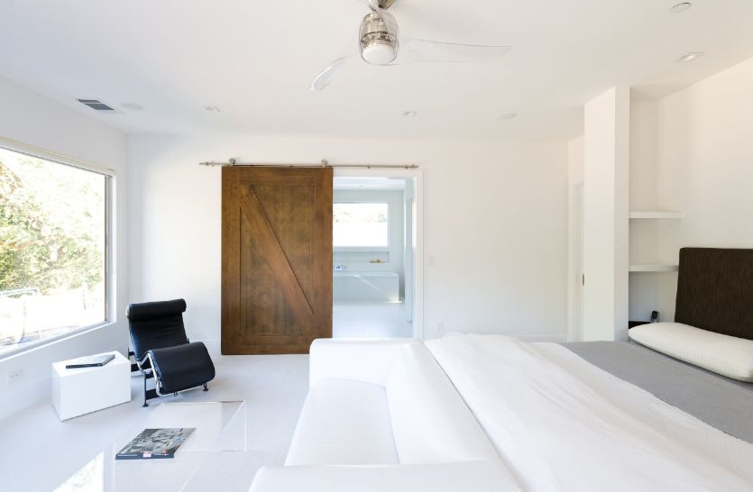 Bedroom with sliding barn door and white walls paint