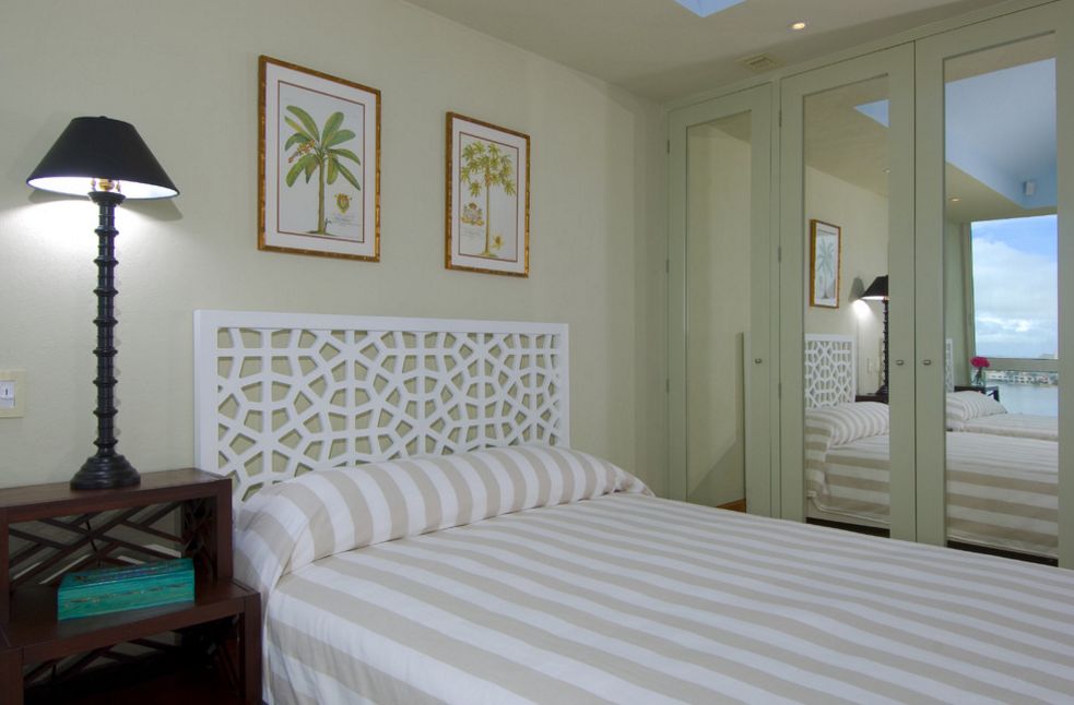 Bedroom with small dressing closet featuring mirrors over the door