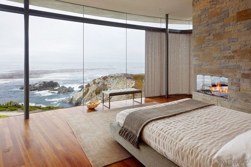 Bedroom with stacked stone fireplace and clif view