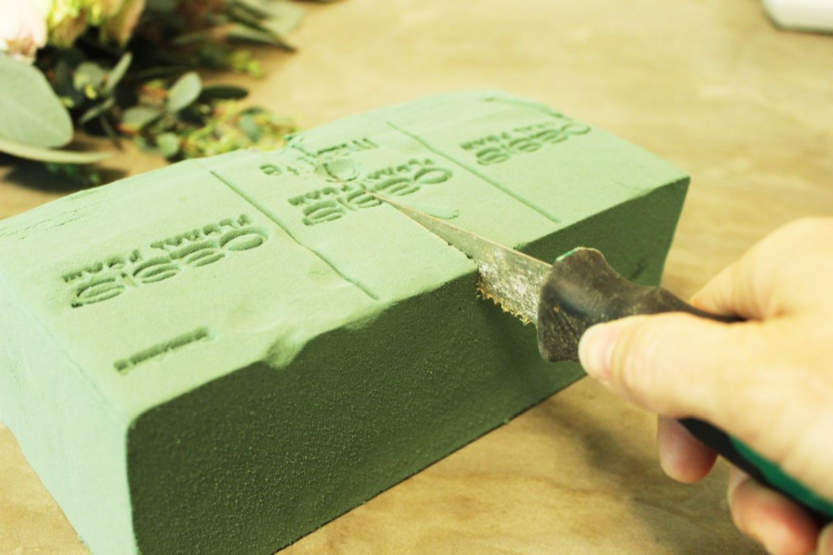 Begin by cutting the floral foam to size with a serrated knife