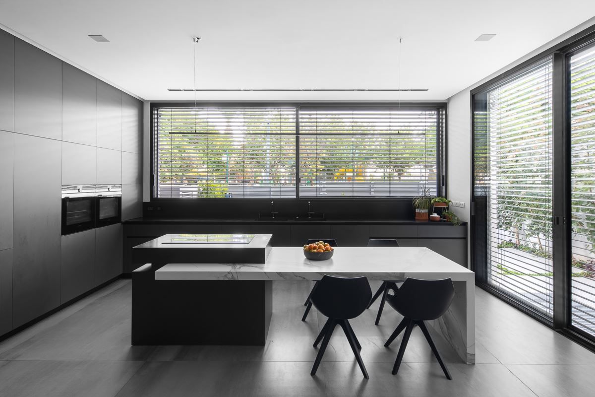 Black kitchen layout with white marble island