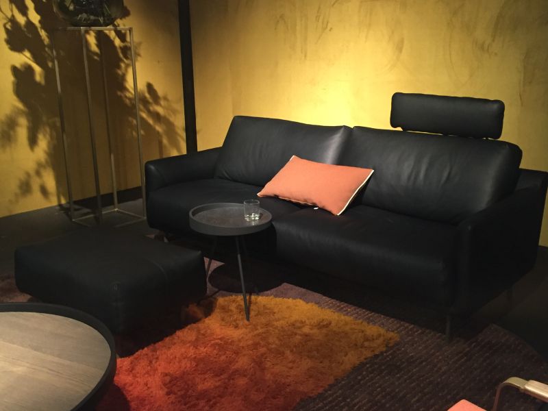 Black leather sofa with orange pillow