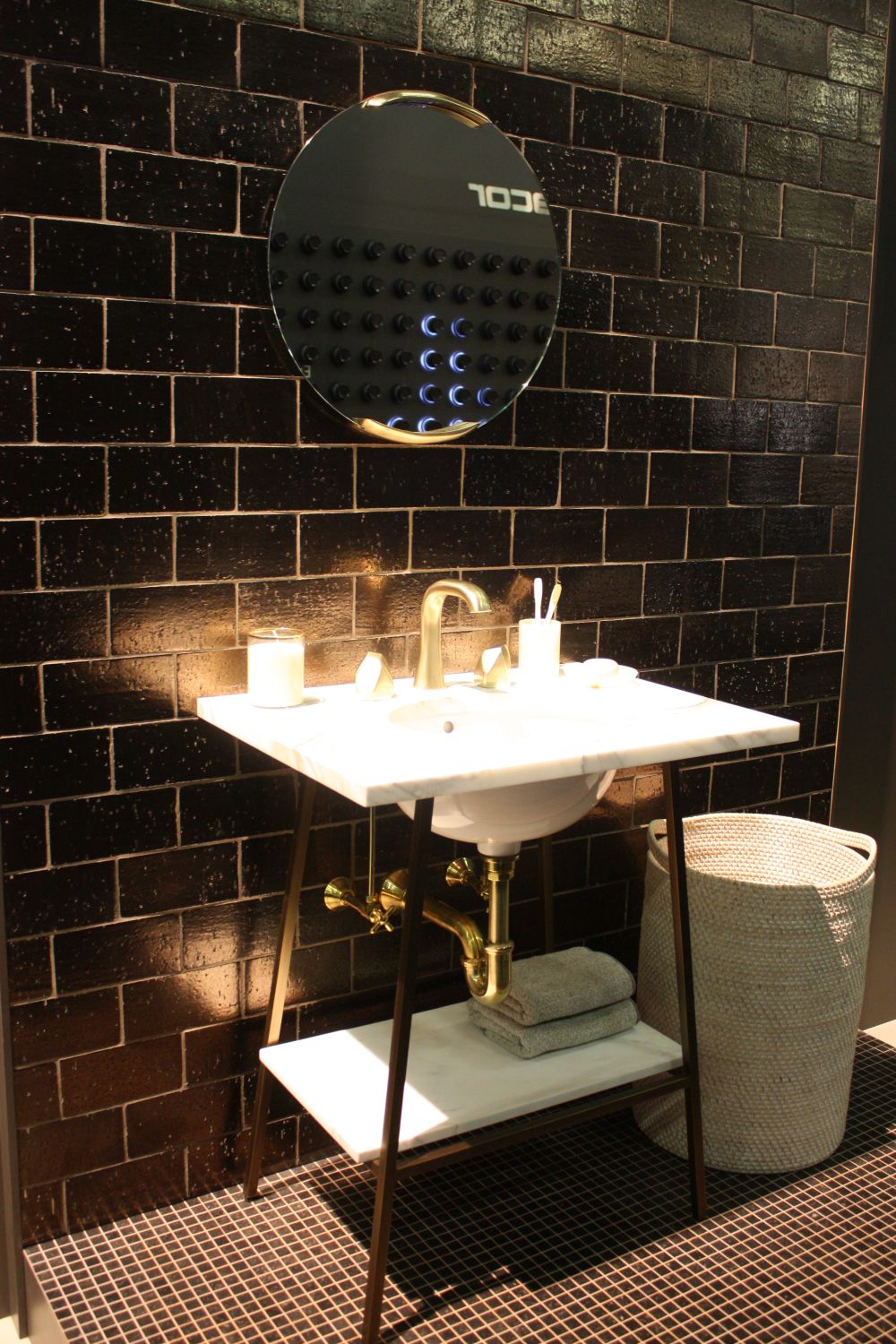 Black subway bathroom tiles and round mirror