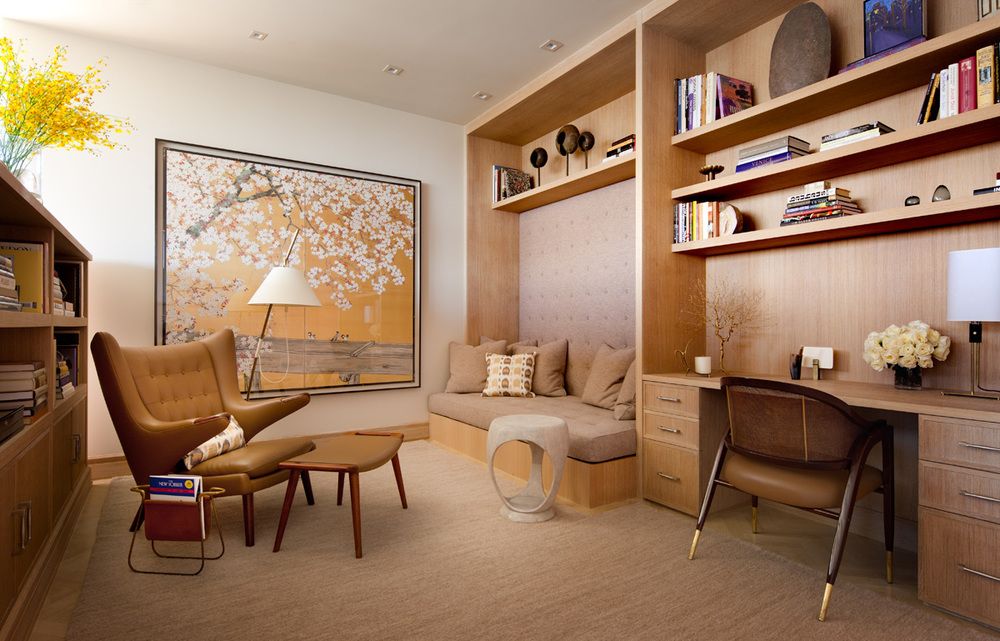 The sitting room is also designed with a neutral palette, but is punctuated by the artwork, the upholstered wall area above the bed, and textured rug.