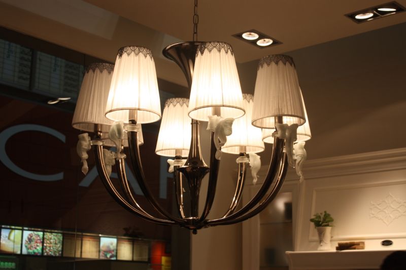Chandeliers are more frequently being used as kitchen island lighting fixtures. This one, shown by Arcari, is a unique mix of elements, such as the old-fashioned bulb shades, quirky glass bow accents and sleek, curved arms.