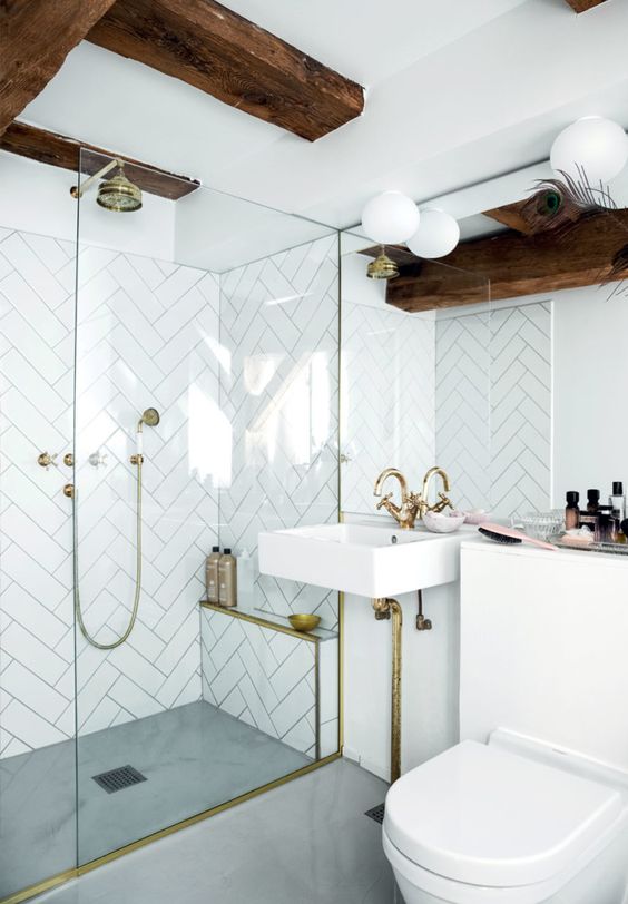 Chevron white wall tiles with concrete floor and brass accents for features