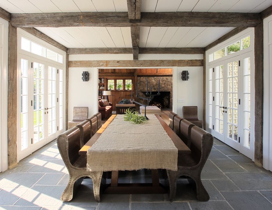 The home's dining room features an enormous table, paired with unusual chairs, reminiscent of church pews.