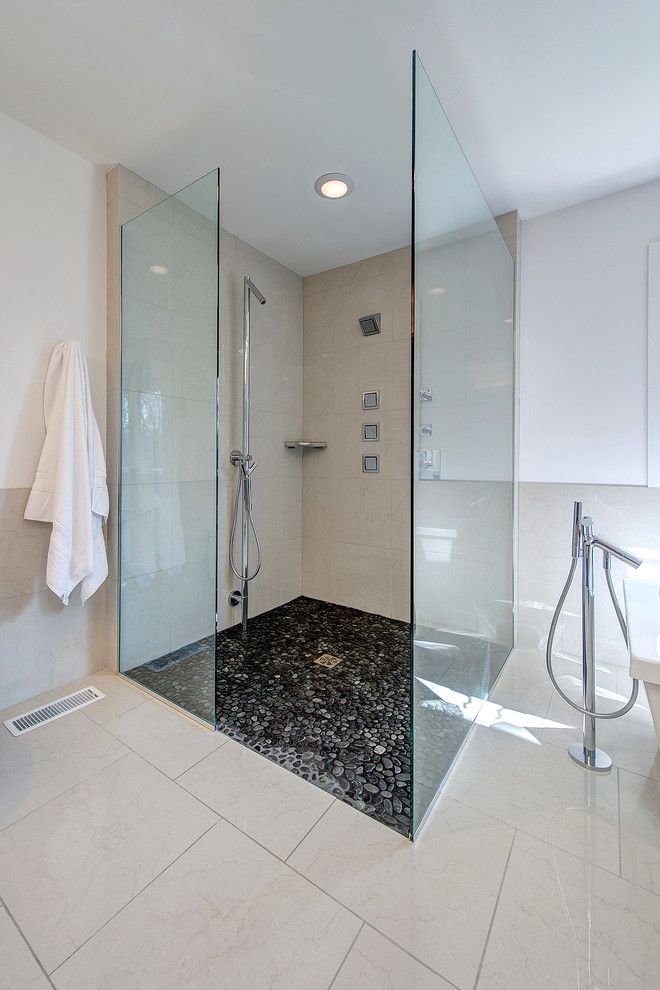 Contemporary bathroom with a glass walls shower and pebbles floor