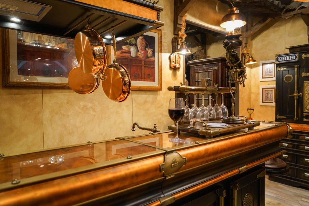 Copper style basement bar with hanging pots featuring an sophisticated antique style