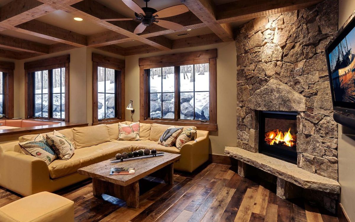 Corner rocks fireplace for a mountain living room featuring hardwood floors