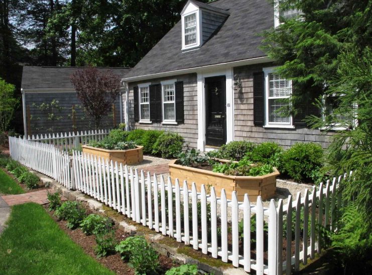 Cottage garden with raised beds and picket white fence