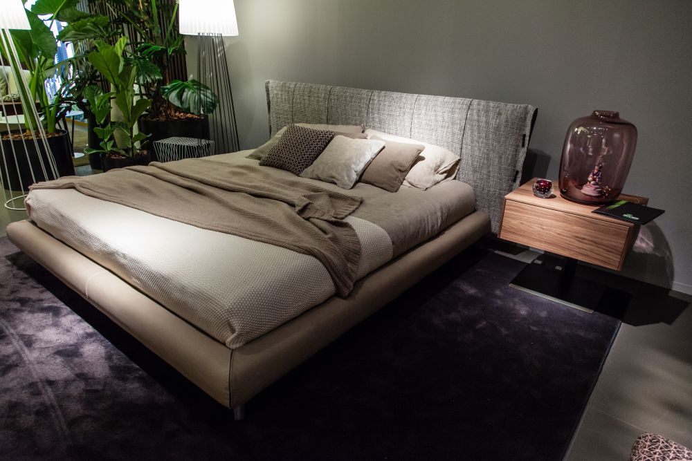 Cream bed design with wood bedside table on a leg