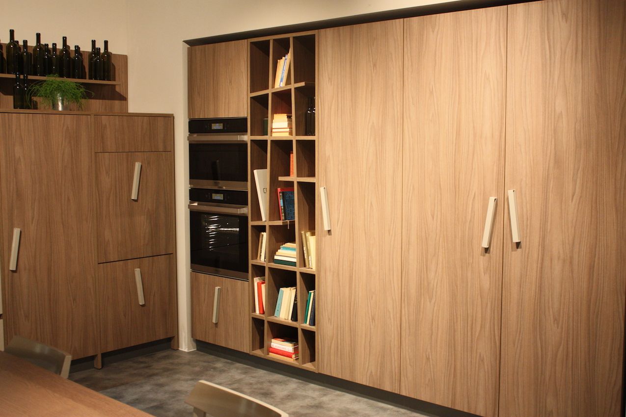 The skewed bar pulls in this Creo cabinetry mimic the off-kilter angles of the bookcase.