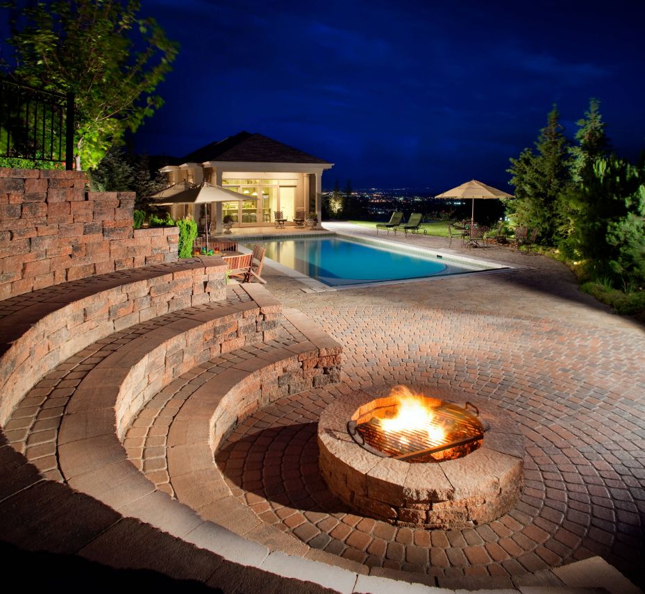 Curved fire pit with seating from rocks closer to the pool