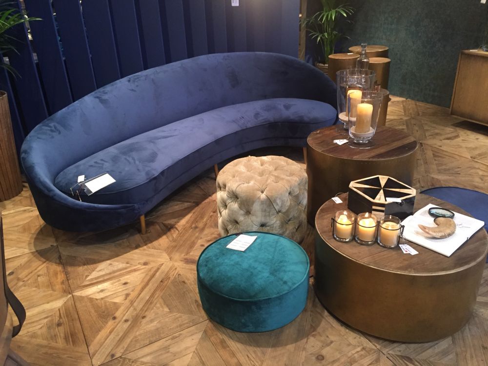 Curved velvet sofa with a selection of round ottomans