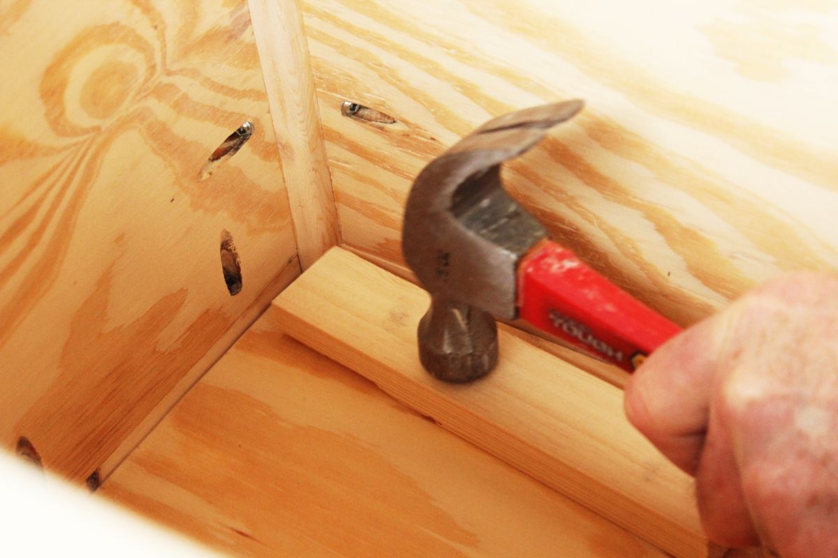 DIY Toy Box consider placing a small piece of scrap wood