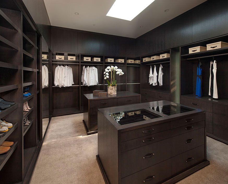 Dark wood walk in closet design with carpet