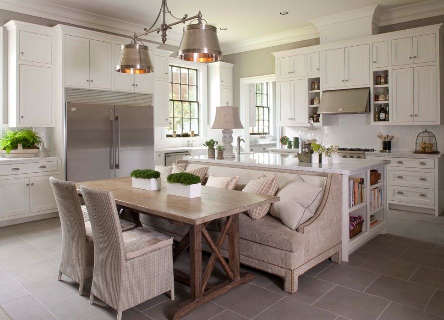 Dining trestle table behind the kitchen island with bench seating and chairs