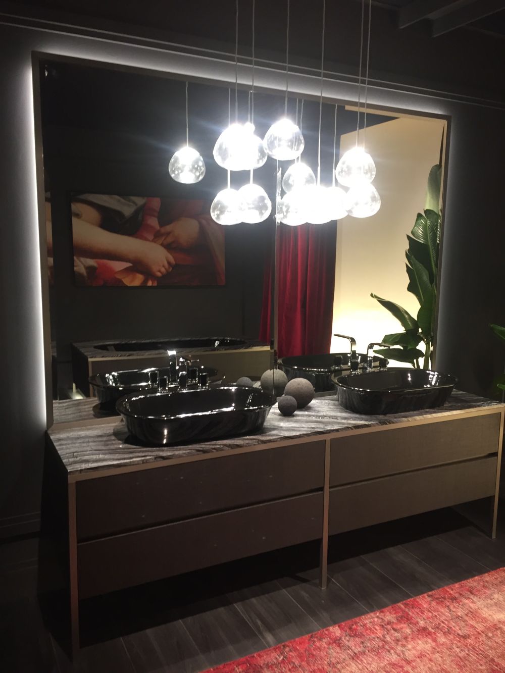 Double sink vanity with large mirror and backlit hanging lighting fixtures