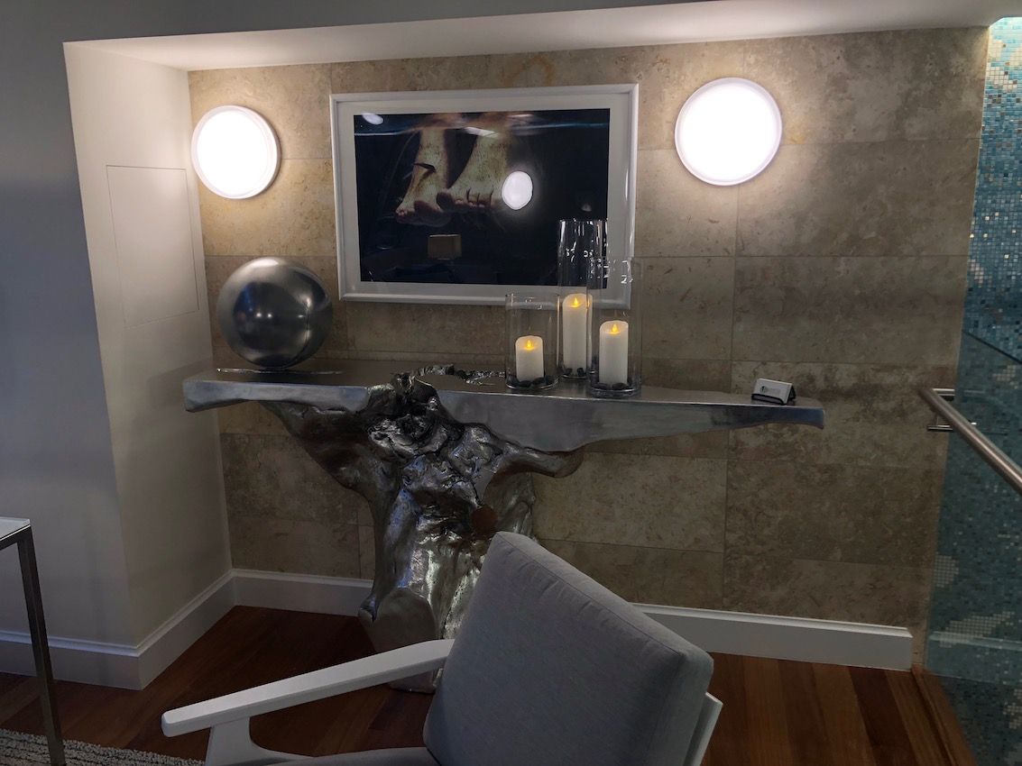 A dramatic silver console is highlighted by round sconces
