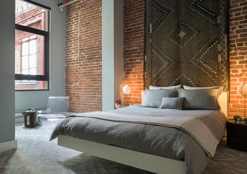 Exposed bricks wall and carpet above the floating bed