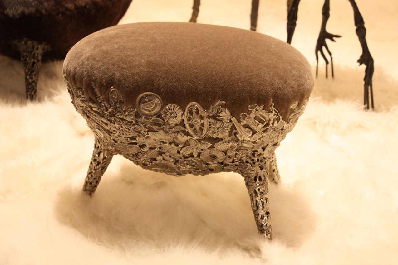 Intricate metalwork frames a soft, upholstered egg shape.