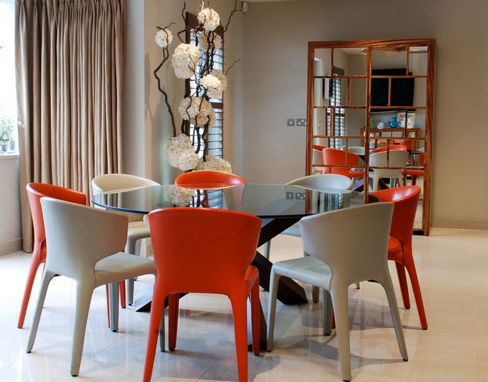 Glass round dining table with colorful chairs