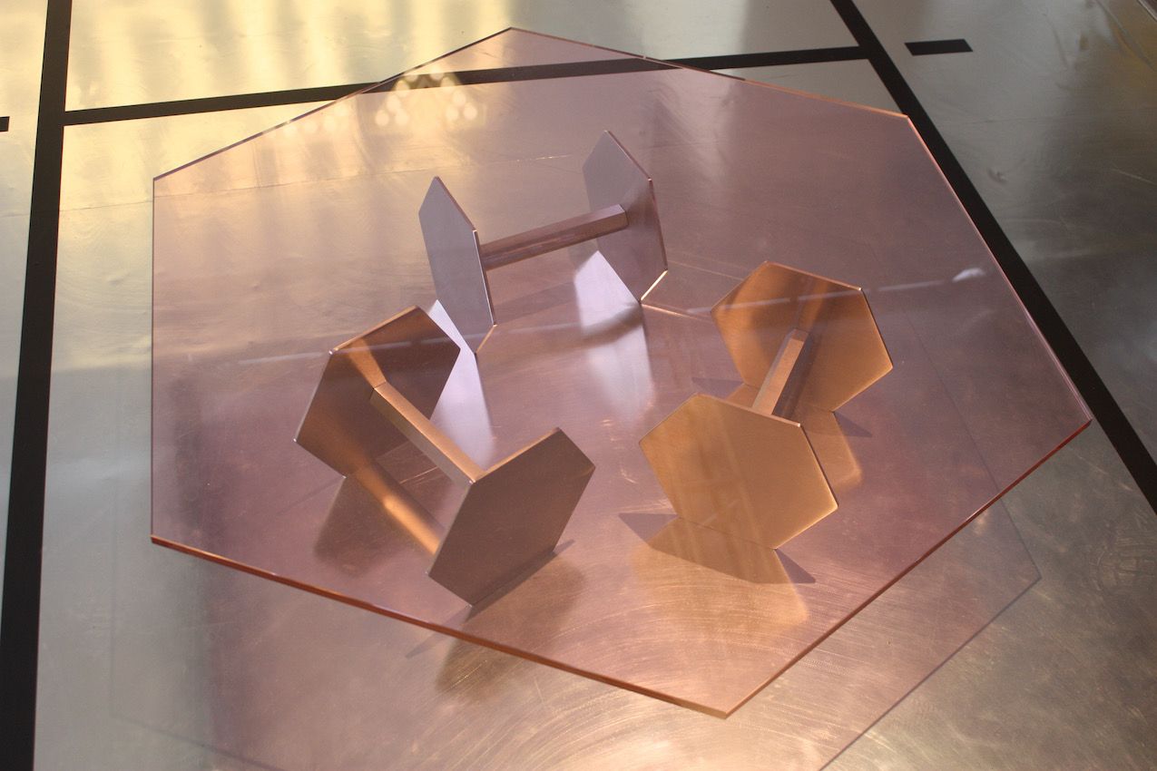 Glass-topped tables are nothing new but this appealing piece combines an unusual choice of pink glass with a base that plays on the concept of a gym and strength.