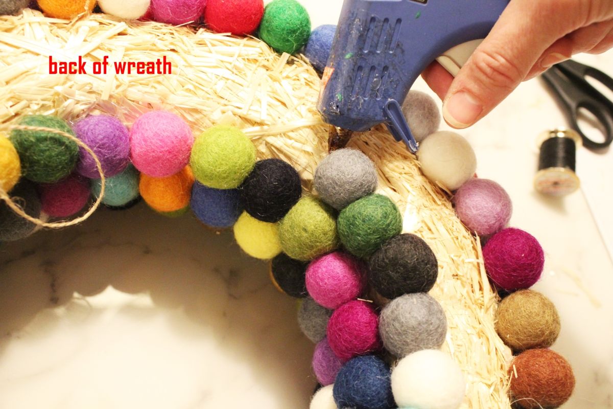 Glue down the final felt ball on the back of the wreath