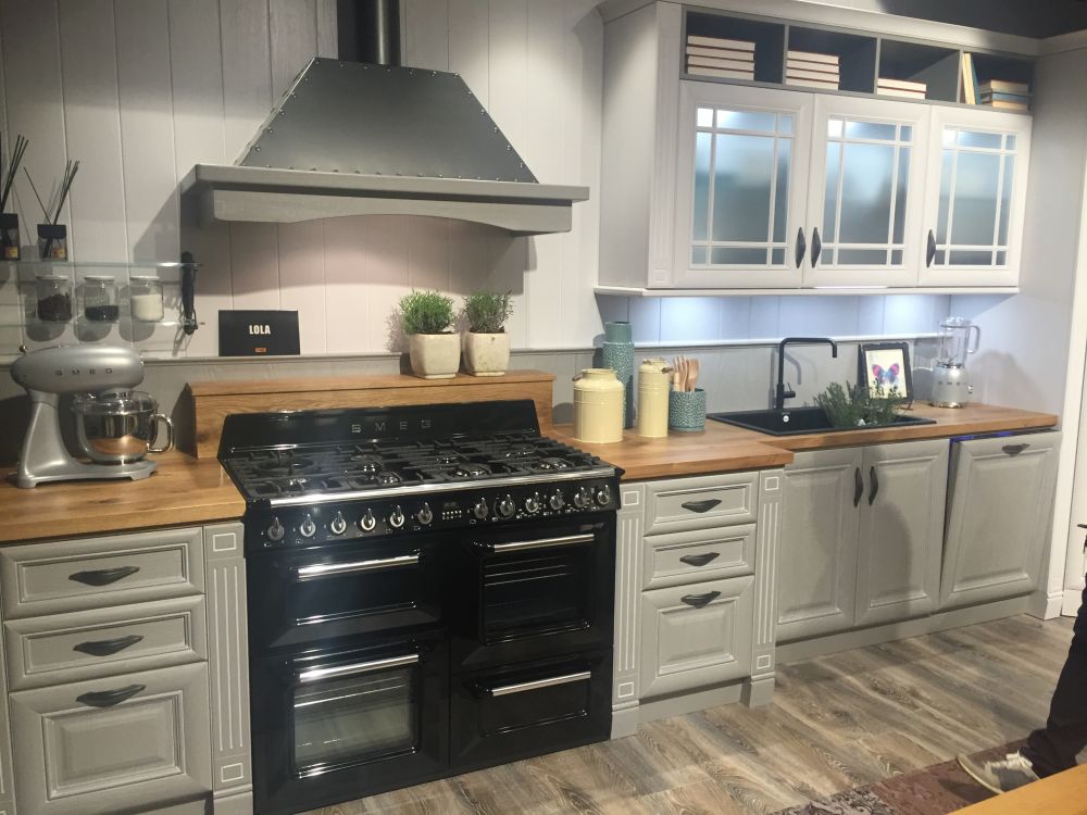 Gray kitchen cabinets with frosted glass doors and black cooktop