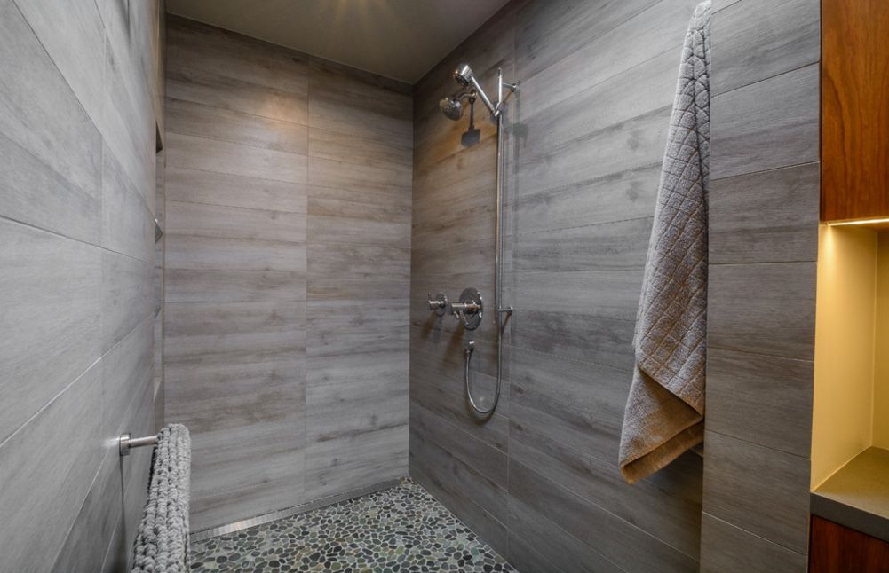 Gray shower walls with pebbles floor