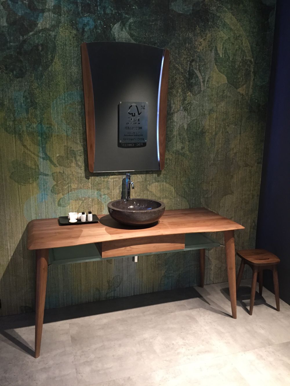 Green bathroom wallpaper and wood vanity with small round vessel sink