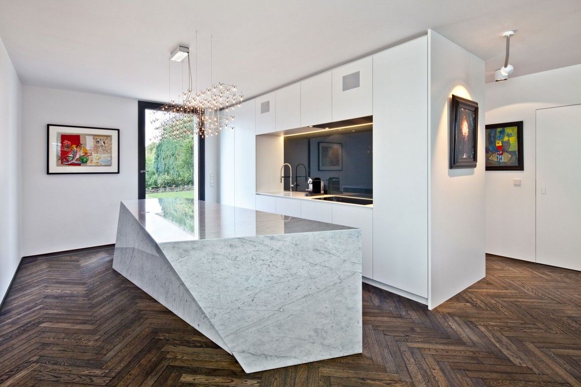 Hardwood chevron kitchen floor with a modern marble island