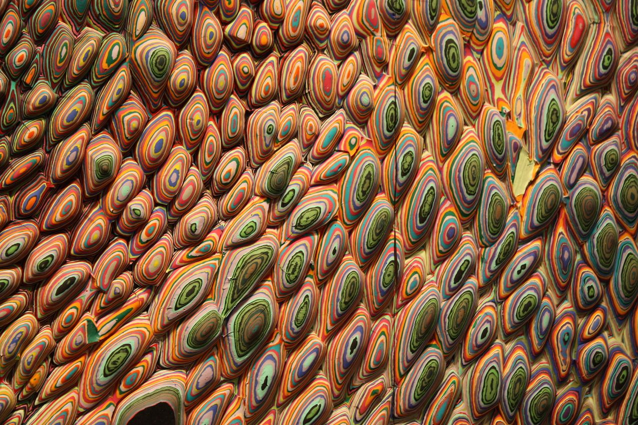 These close-ups show the different layers of paint pours that are applied to small pieces of wood and then assembled into the massive wall piece.