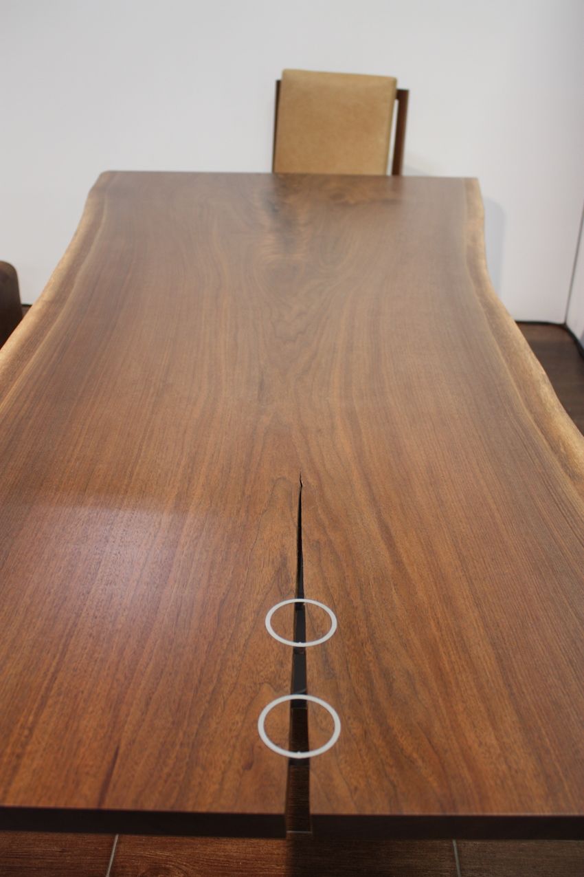 Jupiter also creates a variety of live edge finishings like this table. The round metal pieces are just as much art accent as they are stabilizers.