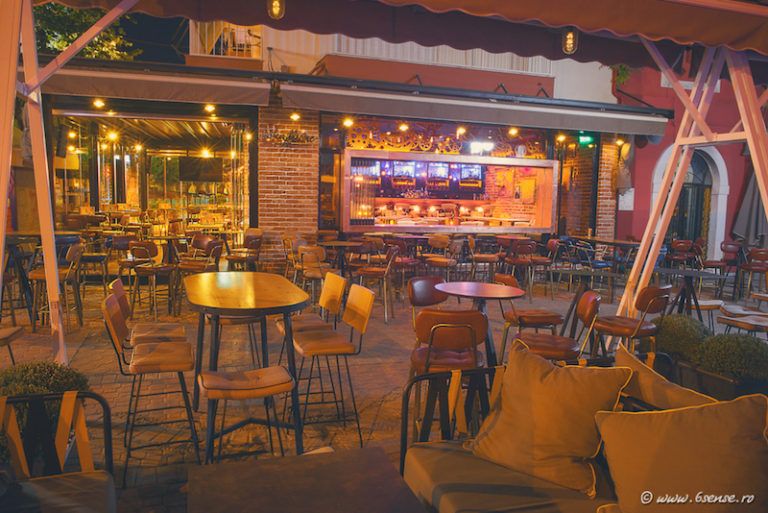 Outside there's a series of small bar-height tables with stools