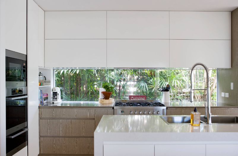 Large contemporary white kitchen with built in appliances and island