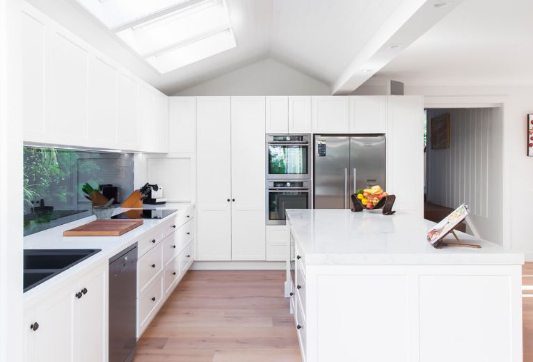 Large white kitchen with window above countertop