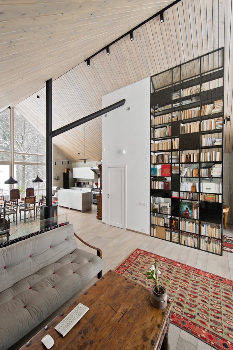 A tall bookcase doubles as a space divider, concealing a cozy nook behind its shelves