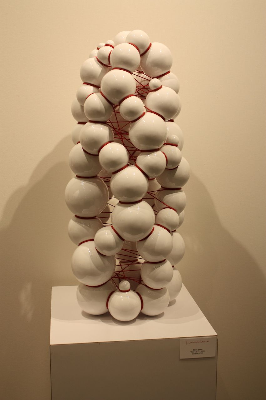 The red string seems to be restraining the ceramic figure from expanding.