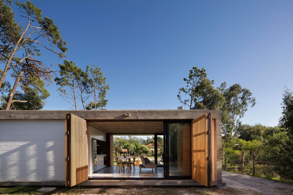 Both the wooden panels and the sliding glass doors can be opened to fully expose the interior spaces to the outdoors
