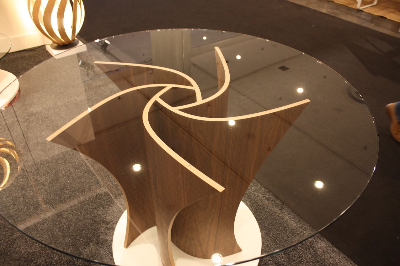 The round glass top highlights the sophisticated design of the table's spiraling base