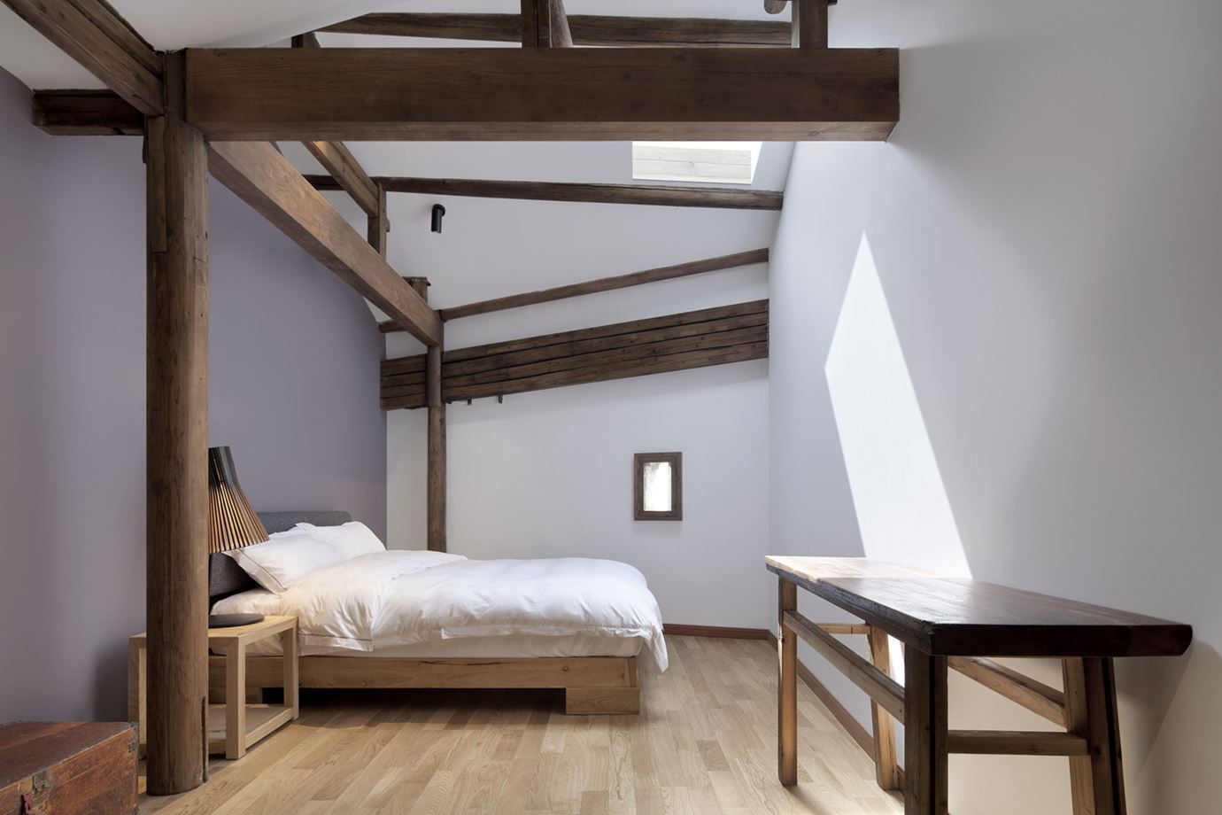 Minimalist bedroom with exposed wood beams