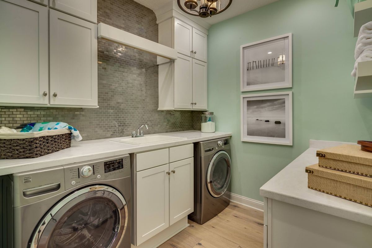 Mint green landry room with gray tiny tiles for backsplash