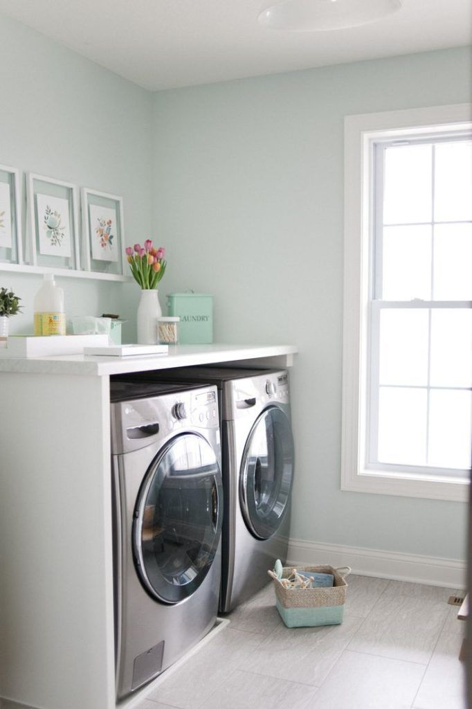 Mint green laundry room with stainless steel washing machine