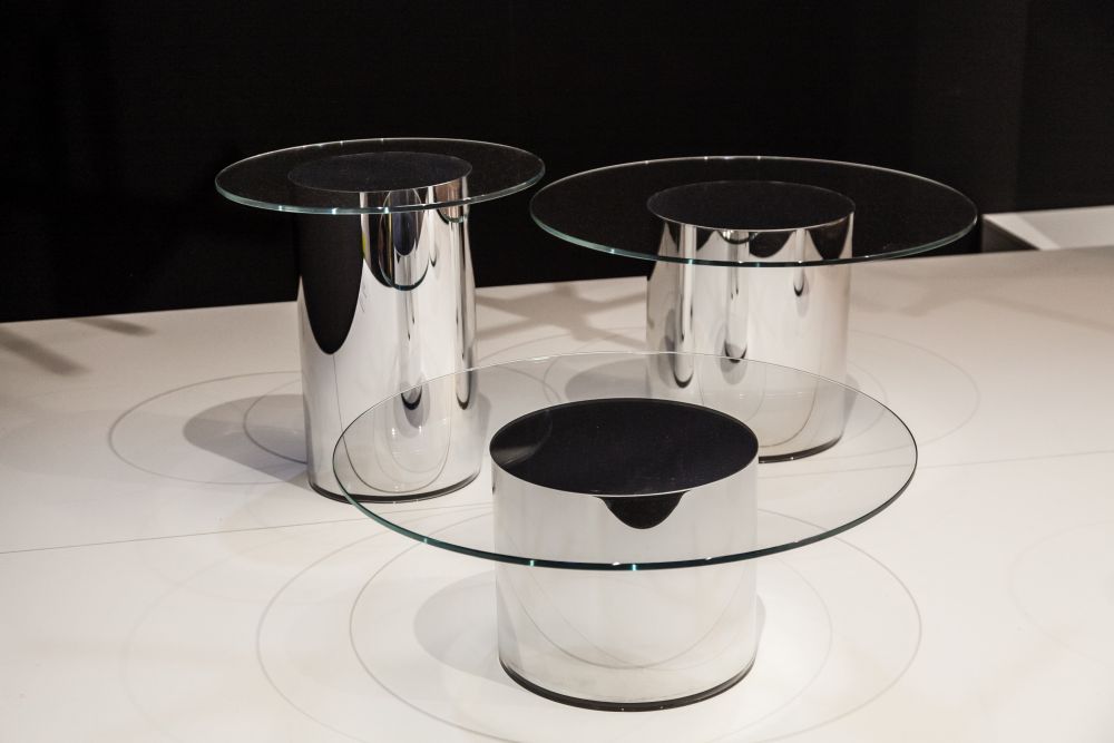 The tables in this series have no visible joints, featuring round glass tops placed on metal cylinders