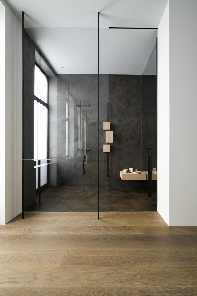 Modern bathroom in black travertine and glass wall