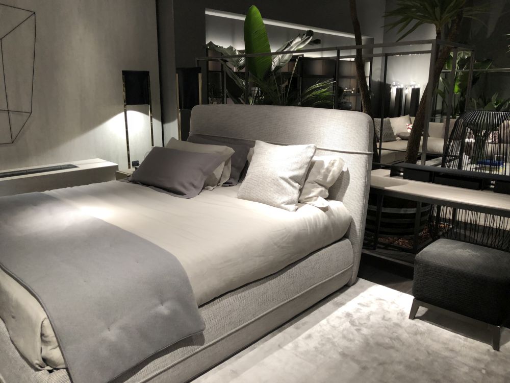 Modern bedroom layout with gray bed and headboard