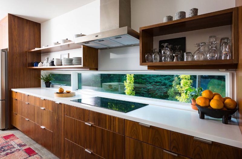 Modern brown MDF kitchen with white countertop and small window