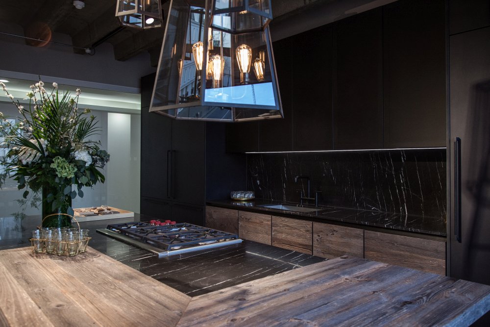 Modern kitchen design featuring black marble and unfinished wood for doors black cabinets